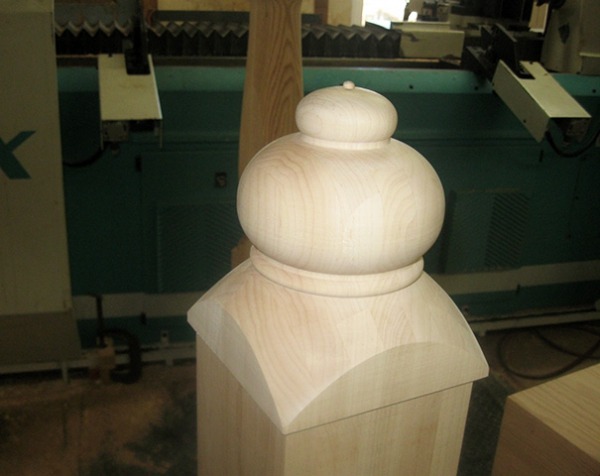 Unfinished wooden finial with a smooth, rounded design for use on newel posts, curtain rods, or other architectural applications.